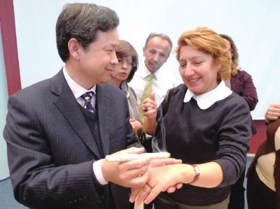 2011年4月13日，山东中医药大学教授王锐（左）为土耳其人演示艾灸。