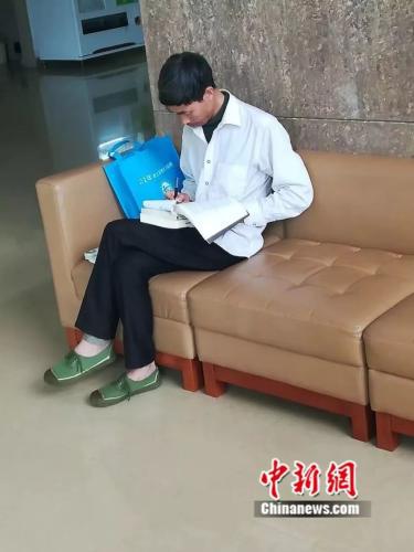 学校学生拍下的园丁大叔在图书馆休息区学习的画面。云南中医学院提供。