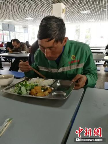 张成刚在学校食堂吃午饭。为了省钱寄回家，他连肉都舍不得吃。胡远航摄。