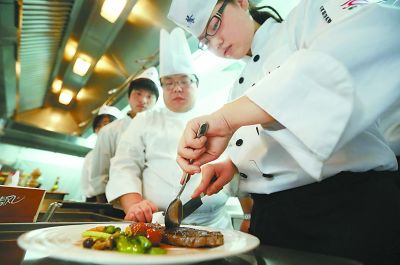 曾在五星酒店任西餐大厨十年的西餐教师刘宇指导小雨主做红酒牛排。