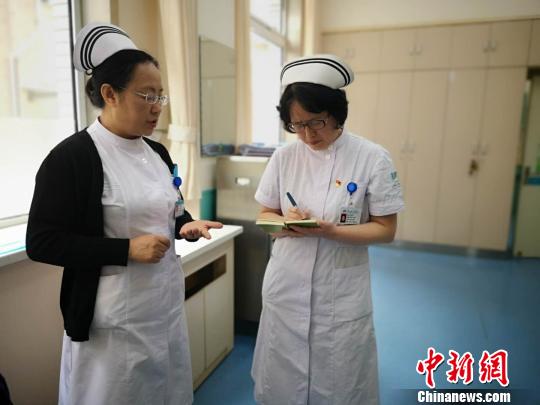 图为医院护理部主任石贞仙和肾内科护士长马玉叶正在商议护理员考核细则。　范丽芳 摄