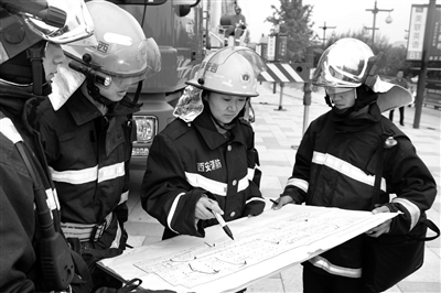 武敏和同事们研究消防设计图纸
